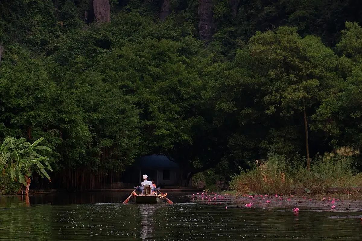 A person rowing using their feet on the Tam Coc boat tour in Vietnam.