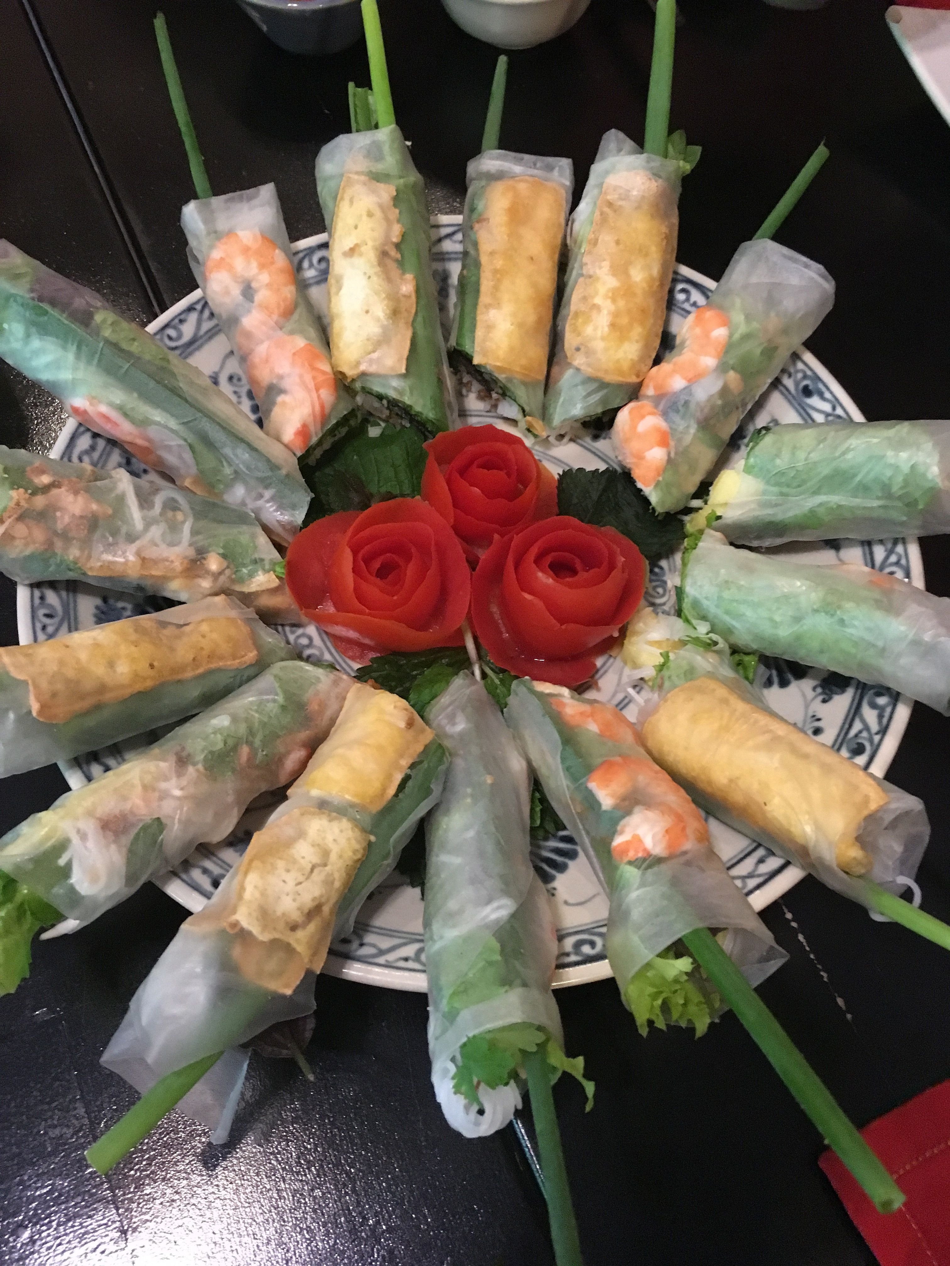 A plate of freshly made spring rolls on a beautiful blue and white plate