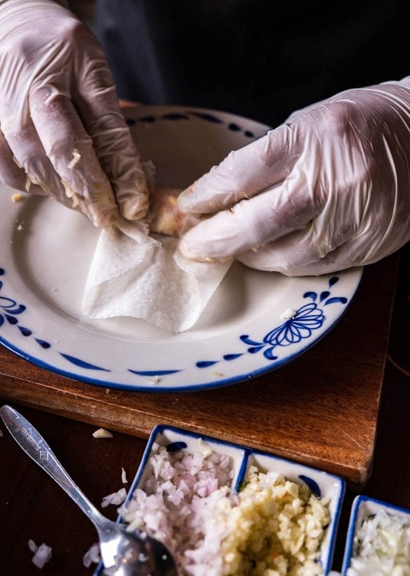 Hands rolling a Vietnamese spring roll