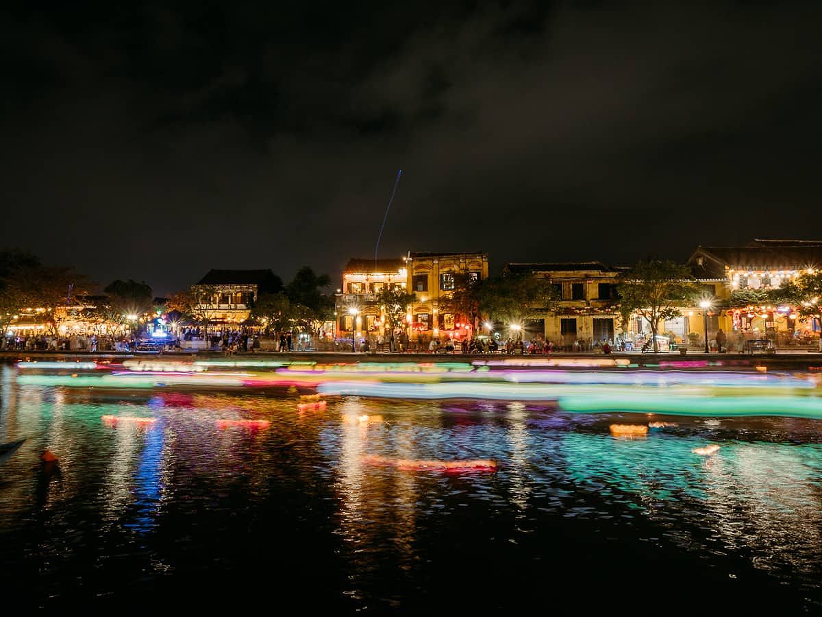 Lanterns and boats going by at night in Hoi An